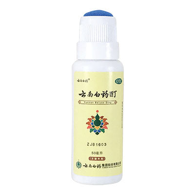 White and cream colored bottle of Yunnan Baiyao Tincture with the cap off.