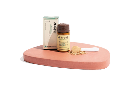 Image of a single bottle of Yunnan Baiyao powder for pets with a spoon of powder sitting on a podium.