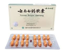 Bright orange Yunnan Baiyao capsules in a blister pack with tan and green box in the background | Best Natural Pets